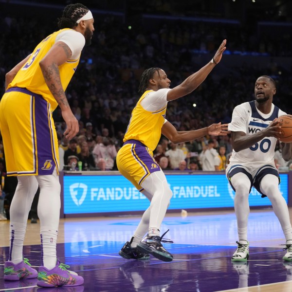 Minnesota Timberwolves forward Julius Randle (30) works toward the basket as Los Angeles Lakers guard Bronny James, center, and forward Anthony Davis defend during the first half of an NBA basketball game, Tuesday, Oct. 22, 2024, in Los Angeles. (AP Photo/Eric Thayer)