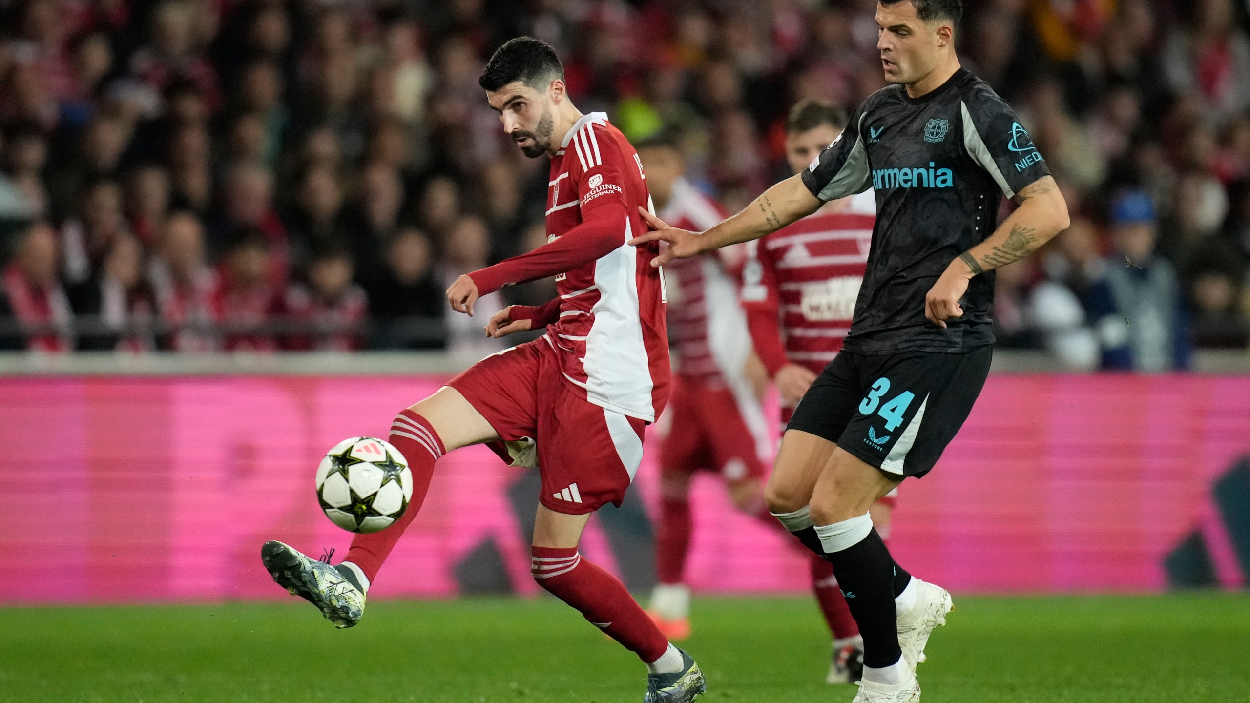 Brest's Pierre Lees-Melou passes the ball in front of Leverkusen's Granit Xhaka during the Champions League opening phase soccer match between Brest and Bayer Leverkusen in Guingamp, western France, Wednesday, Oct. 23, 2024. (AP Photo/Christophe Ena)