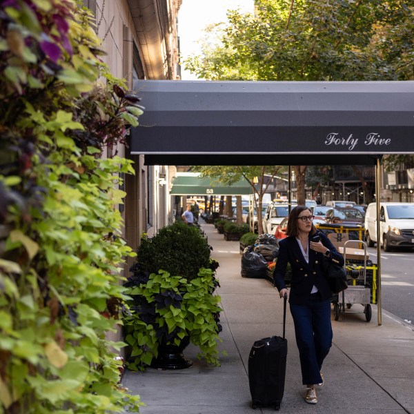 A person walks past the 45 East 66th Street, a building that includes an apartment owned by former New York City Mayor Rudy Giuliani, Wednesday, Oct. 23, 2024, in New York. (AP Photo/Yuki Iwamura)