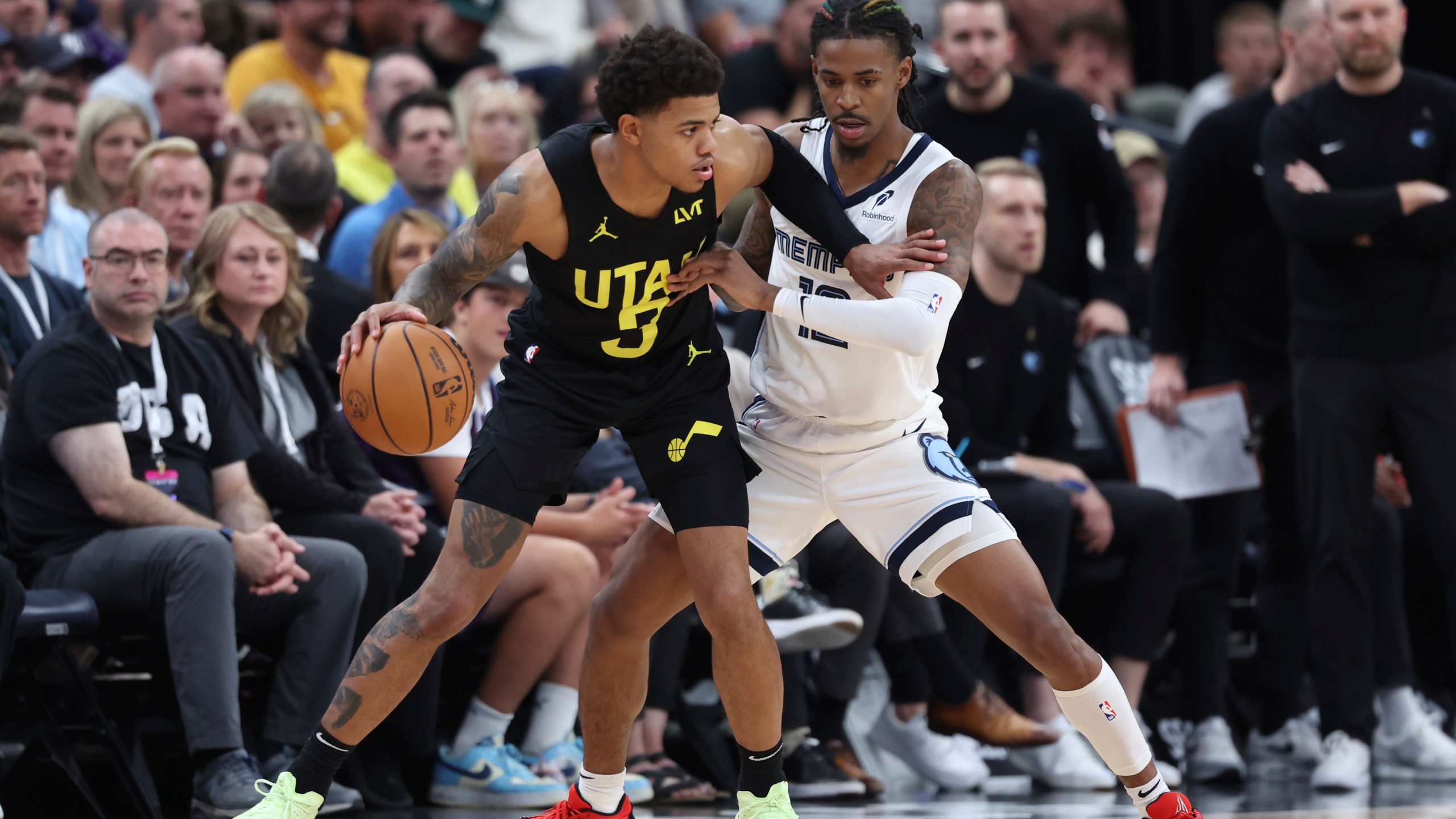 Utah Jazz guard Keyonte George (3) dribbles the ball while Memphis Grizzlies guard Ja Morant (12) defends during the first half of an NBA basketball game, Wednesday, Oct. 23, 2024, in Salt Lake City. (AP Photo/Rob Gray)