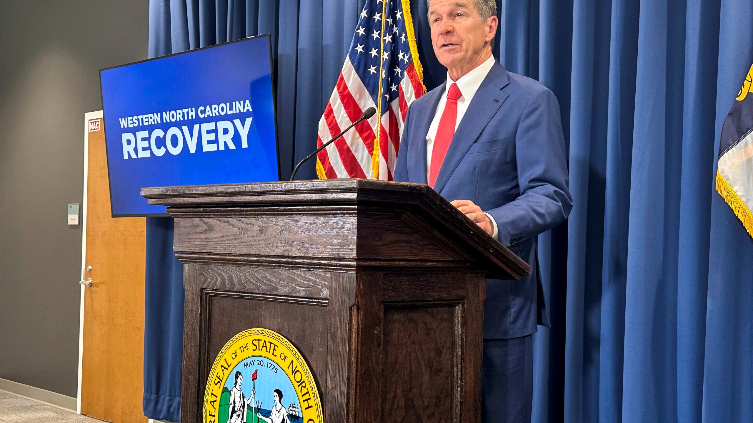 North Carolina Gov. Roy Cooper unveils a report about damages caused by Hurricane Helene and his $3.9 billion request to the General Assembly for recovery initiatives during a press conference at the Albemarle Building in Raleigh, N.C., Wednesday, Oct. 23, 2024. (AP Photo/Gary D. Robertson)