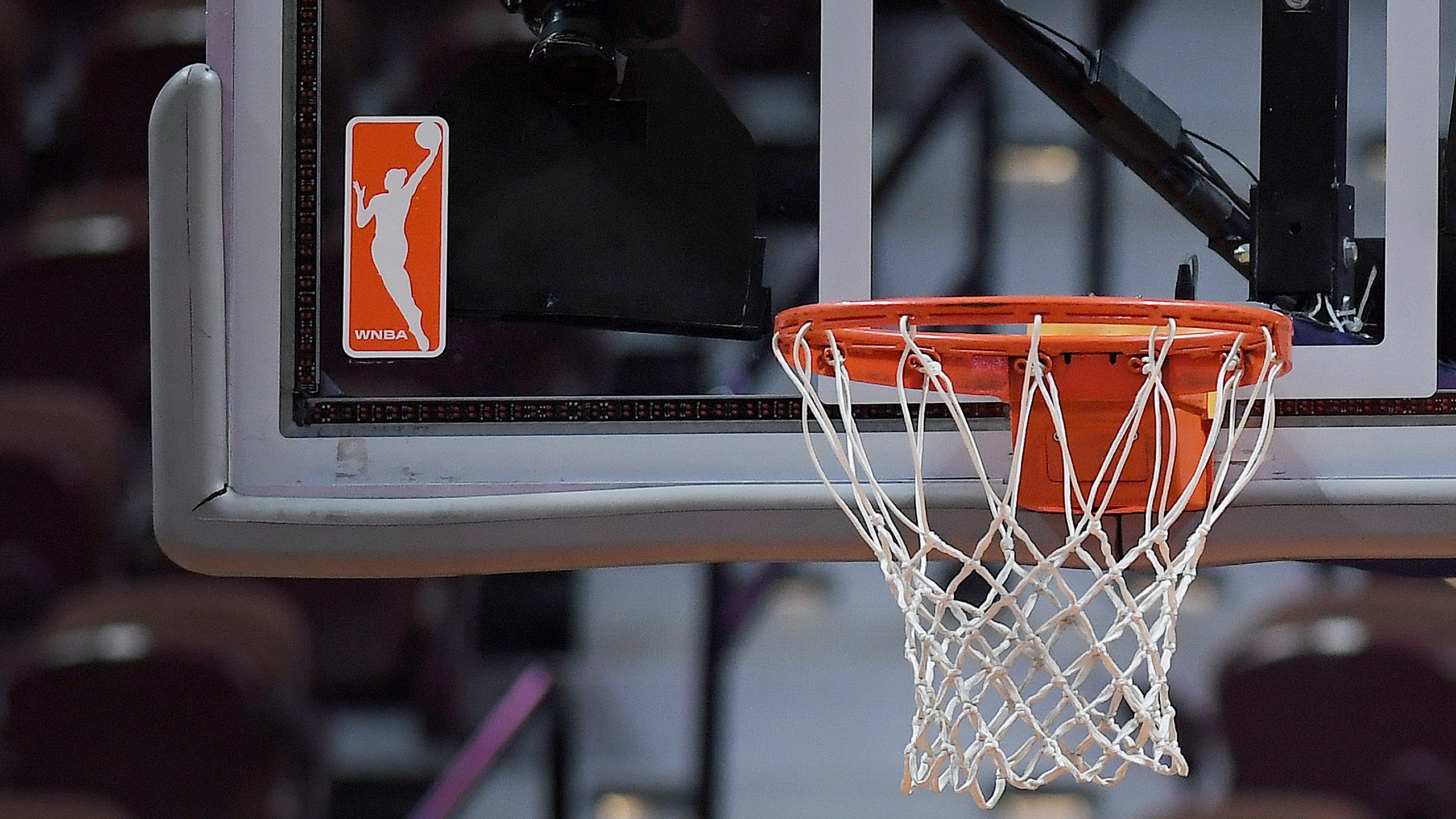 FILE - The WNBA logo and hoop are seen at a WNBA basketball game at Mohegan Sun Arena, Tuesday, May 14, 2019, in Uncasville, Conn. (AP Photo/Jessica Hill, File)