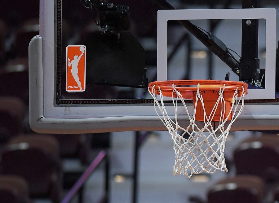 FILE - The WNBA logo and hoop are seen at a WNBA basketball game at Mohegan Sun Arena, Tuesday, May 14, 2019, in Uncasville, Conn. (AP Photo/Jessica Hill, File)