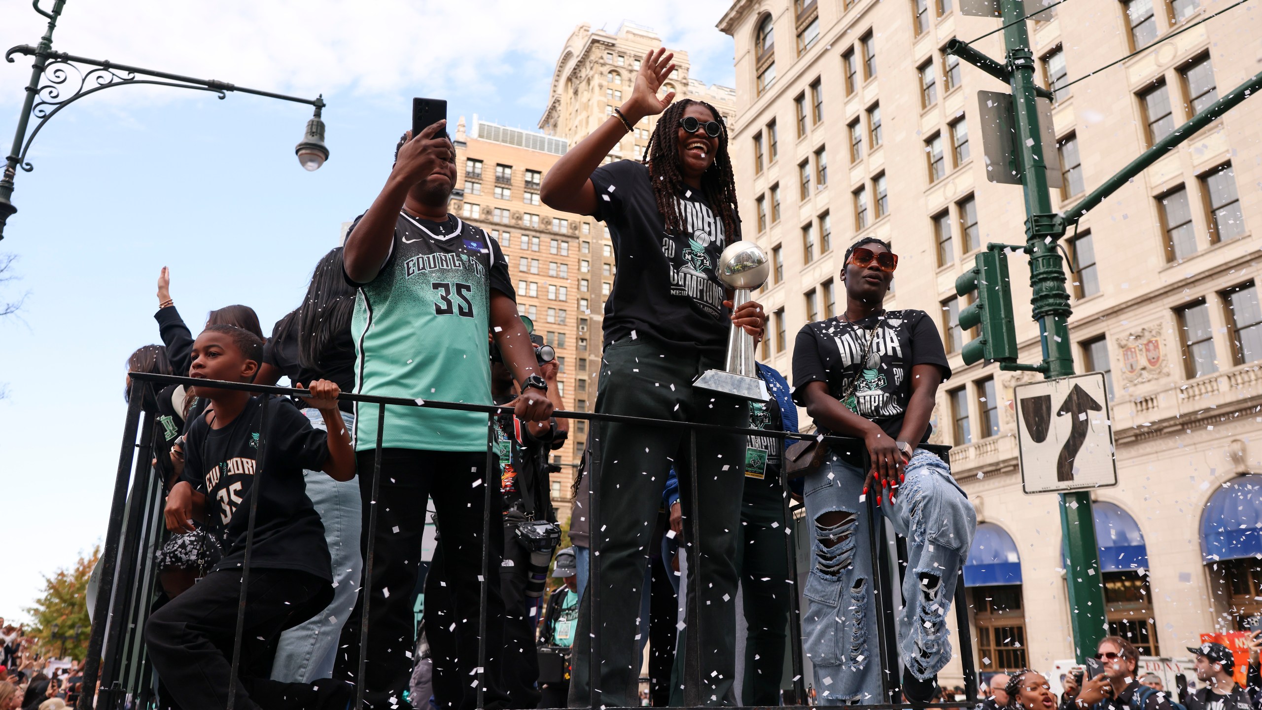 New York Liberty forward Jonquel Jones, center, waves as she rides on a float holding the MVP trophy to celebrate the team's WNBA basketball championship over the Minnesota Lynx, Thursday, Oct. 24, 2024, in New York. (AP Photo/Yuki Iwamura)