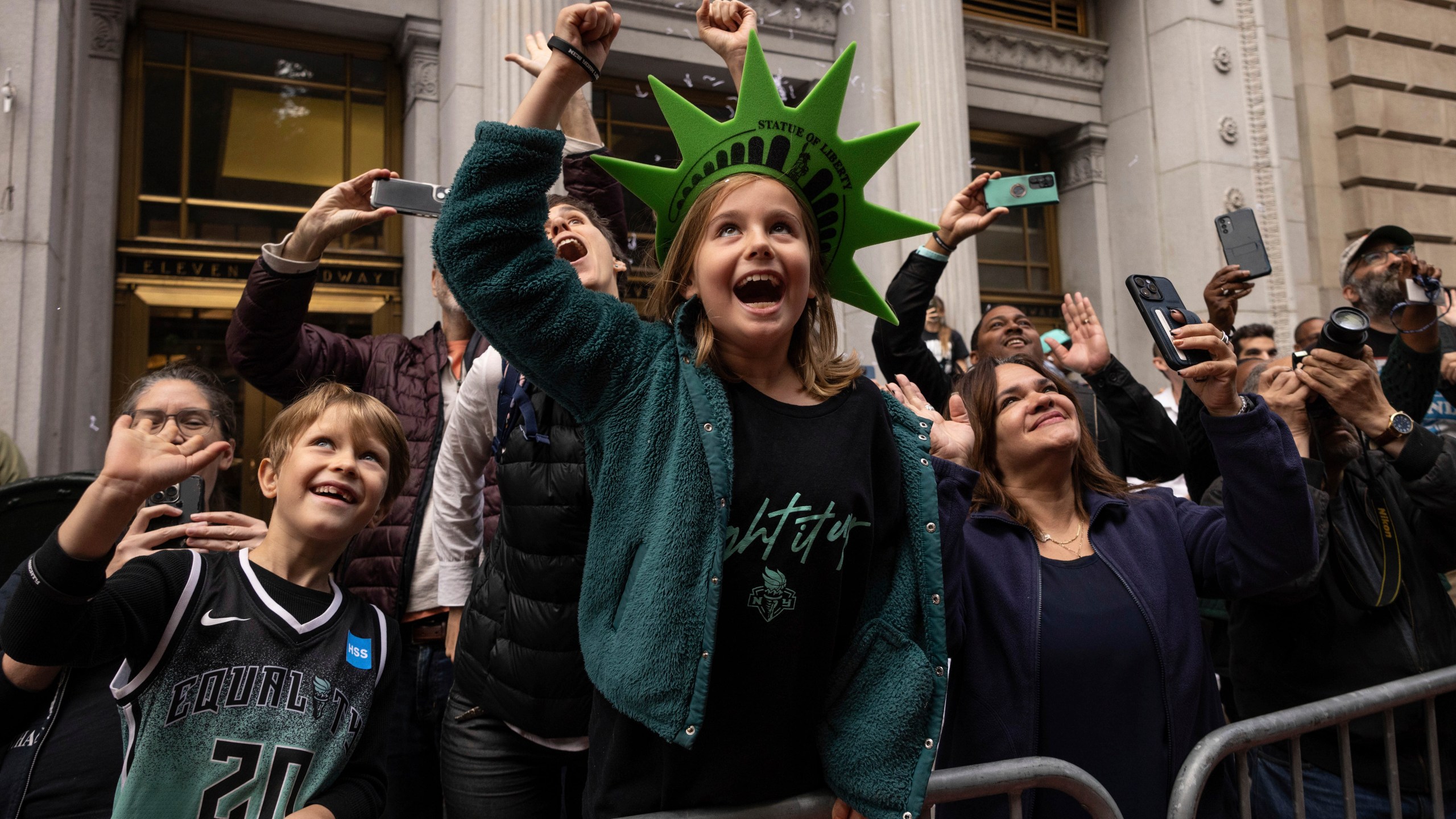 Spectators react as a float with members of the New York Liberty make its way up Broadway during the WNBA basketball championship parade Thursday, Oct. 24, 2024, in New York. (AP Photo/Yuki Iwamura)