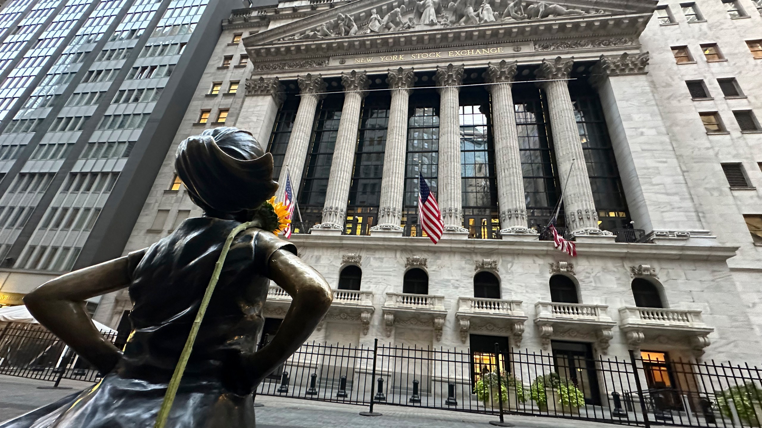 FILE - The Fearless Girl statue, with a flower draped on the shoulder, stands outside the New York Stock Exchange on Oct. 23, 2024. (AP Photo/Peter Morgan, File)