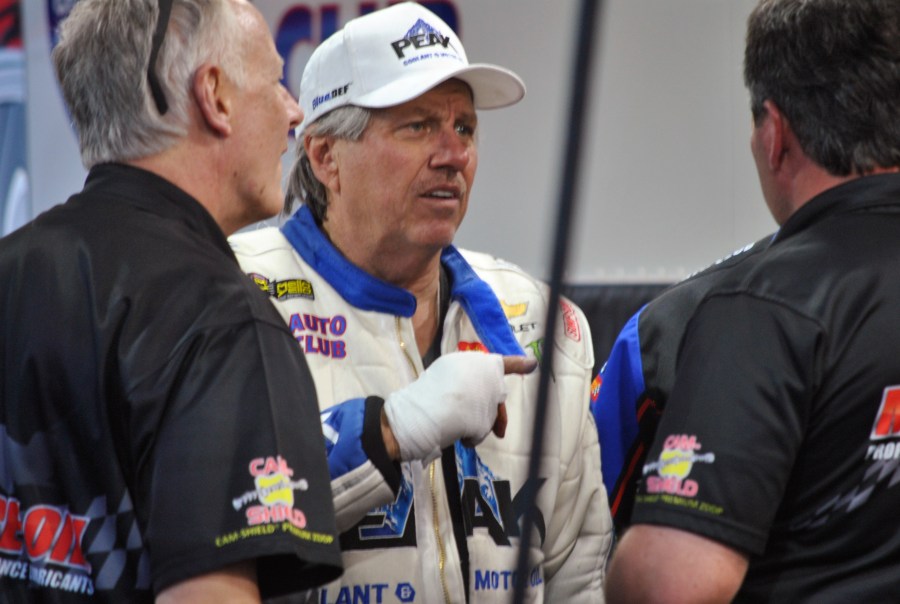 FILE - John Force talks to crew members after his Funny Car blew an engine and destroyed the body of his dragster, Friday, March 16, 2018, at the NHRA Gatornationals in Gainesville, Fla. (AP Photo/Mark Long, File)