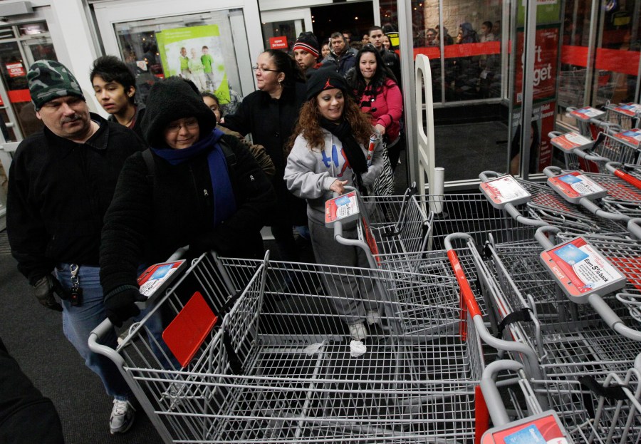 FILE - Shoppers rush into a Kmart store in Chicago on on Nov. 25, 2011 for Black Friday sale. (AP Photo/Nam Y. Huh, File)