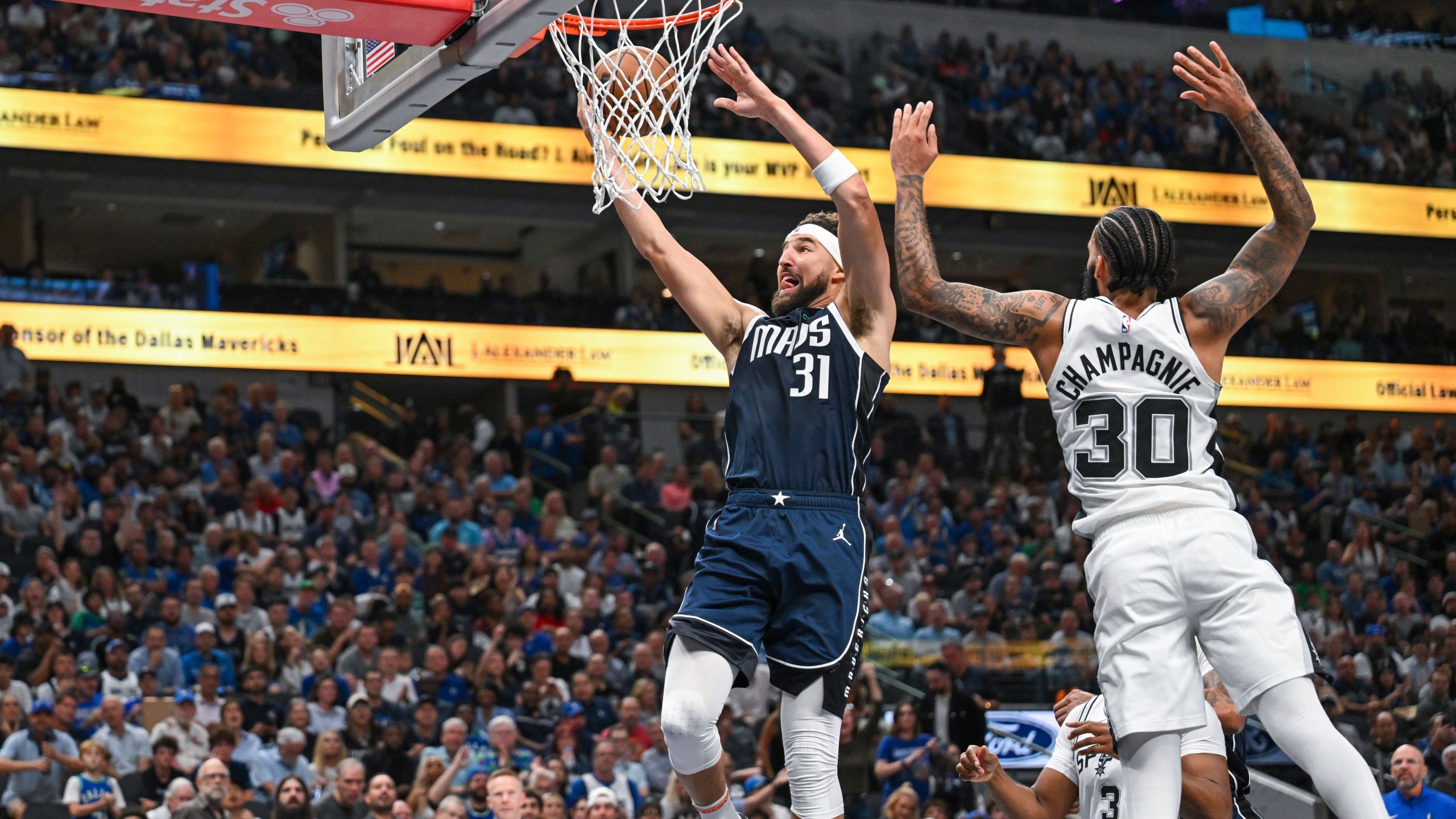 Dallas Mavericks' guard Klay Thompson (31) goes for a layup as he is guarded by San Antonio Spurs' forward Julian Champagnie (30) during the second half of an NBA basketball game, Thursday, Oct. 24, 2024, in Dallas, Texas. (AP Photo/Albert Pena)