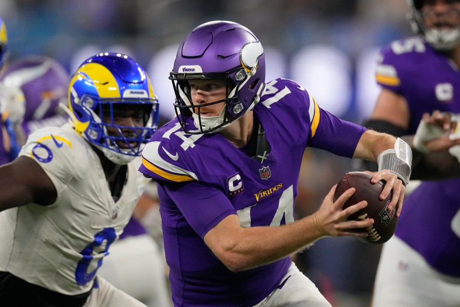 Minnesota Vikings quarterback Sam Darnold (14) scrambles while pressured by Los Angeles Rams linebacker Byron Young (0) during the first half of an NFL football game Thursday, Oct. 24, 2024, in Inglewood, Calif. (AP Photo/Mark J. Terrill)