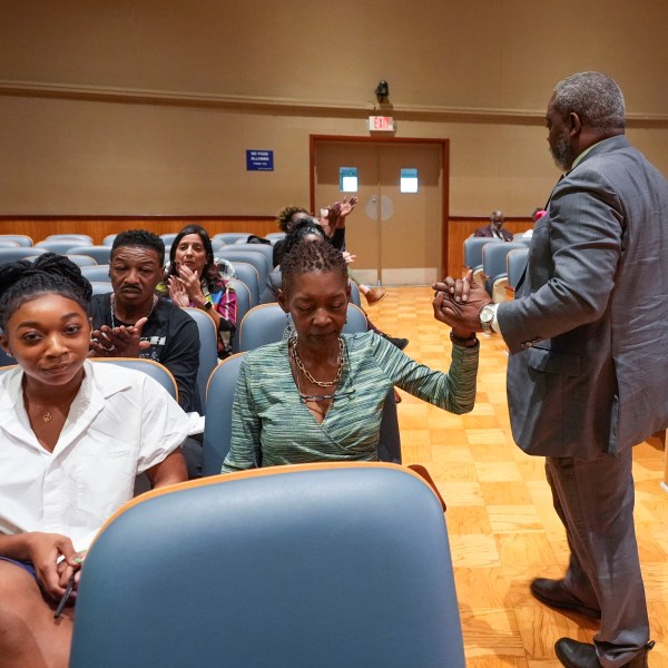 Sundiata Haley, son of Oretha Castle Haley, is congratulated by civil rights attorney Tracy L. Washington, as he walks to his seat after speaking during a city council hearing regarding the dispute over Oretha Castle Haley's former home, and plans by others to create a museum, in New Orleans, Thursday, Oct. 24, 2024. (AP Photo/Gerald Herbert)