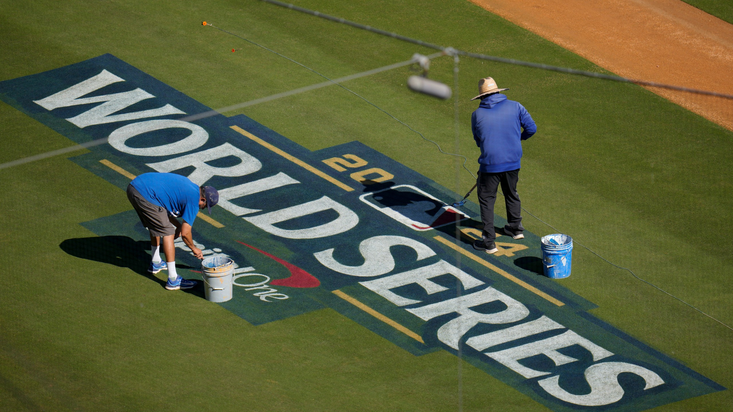 Workers prepare the field for the baseball World Series between the Los Angeles Dodgers and the New York Yankees, Thursday, Oct. 24, 2024, in Los Angeles. (AP Photo/Julio Cortez)