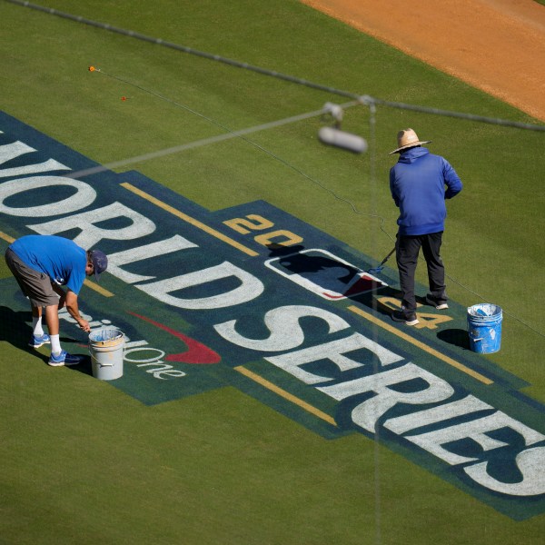 Workers prepare the field for the baseball World Series between the Los Angeles Dodgers and the New York Yankees, Thursday, Oct. 24, 2024, in Los Angeles. (AP Photo/Julio Cortez)