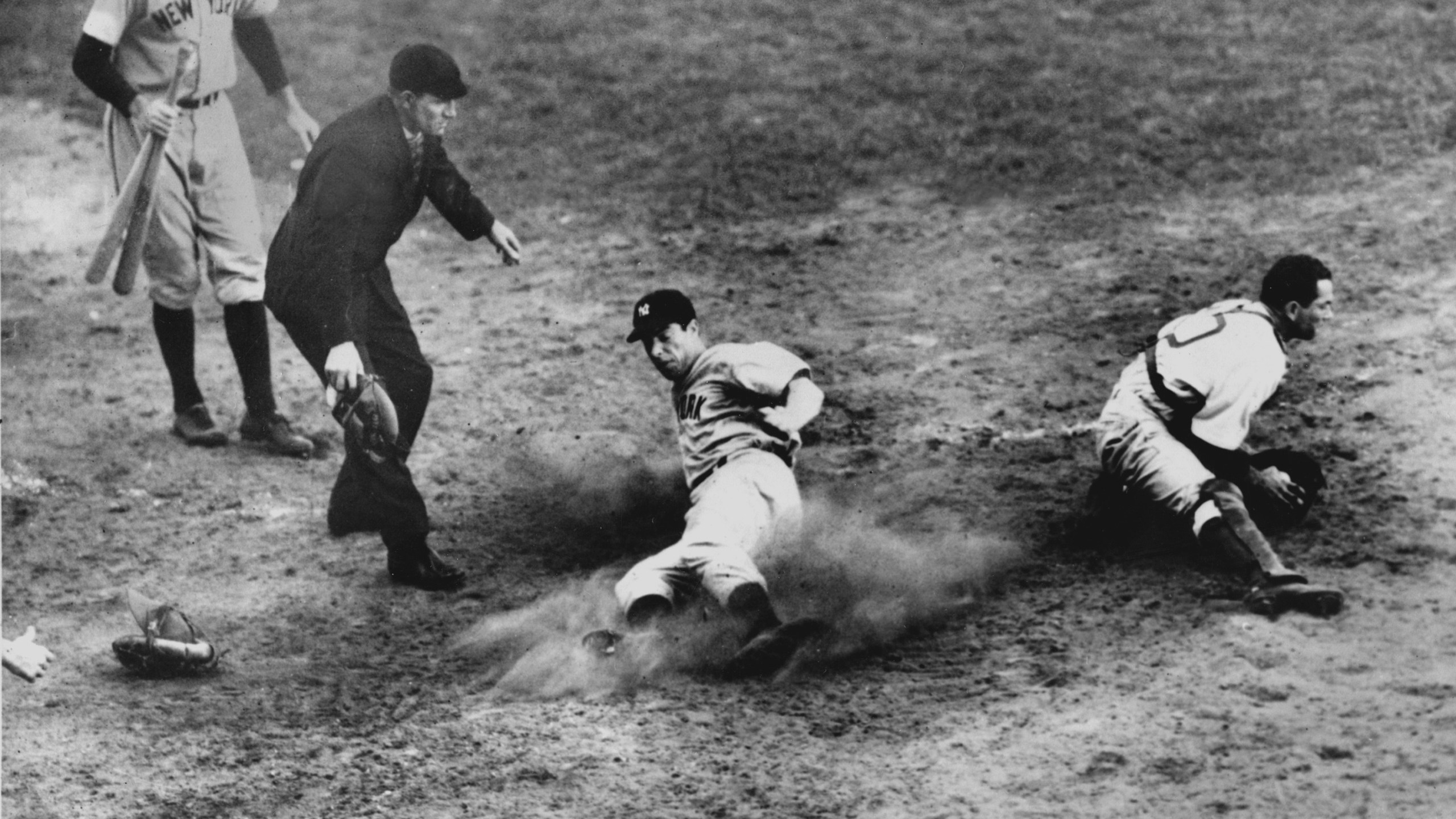 FILE - New York Yankees outfielder Joe DiMaggio (5) slides home safely in the ninth inning to score his team's fifth and winning run in Game 4 of the World Series against the Brooklyn Dodgers at Ebbets Field, Brooklyn, N.Y., Oct. 5, 1941. Dodgers catcher Mickey Owen has the ball. The Yankees won 7 to 4. (AP Photo/Murray Becker, File)