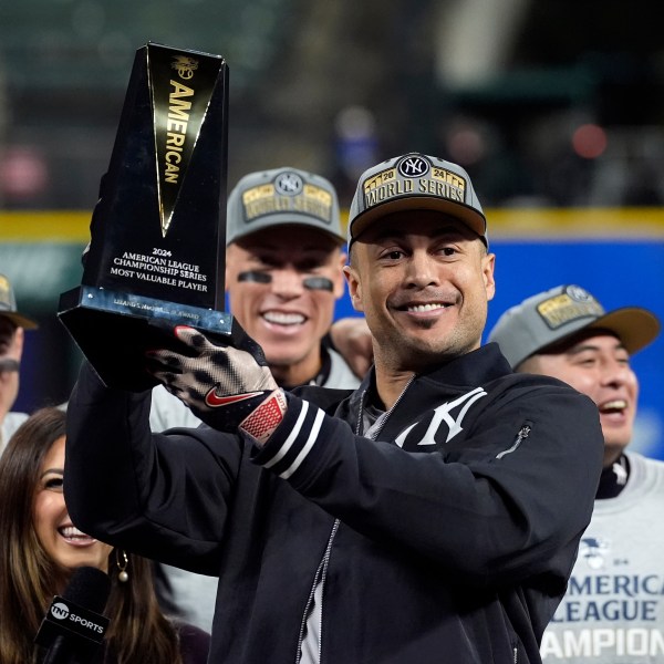 New York Yankees' Giancarlo Stanton holds up the MVP trophy after Game 5 of the baseball AL Championship Series Sunday, Oct. 20, 2024, in Cleveland. The Yankees won 5-2 to advance to the World Series. (AP Photo/Godofredo A. Vásquez )