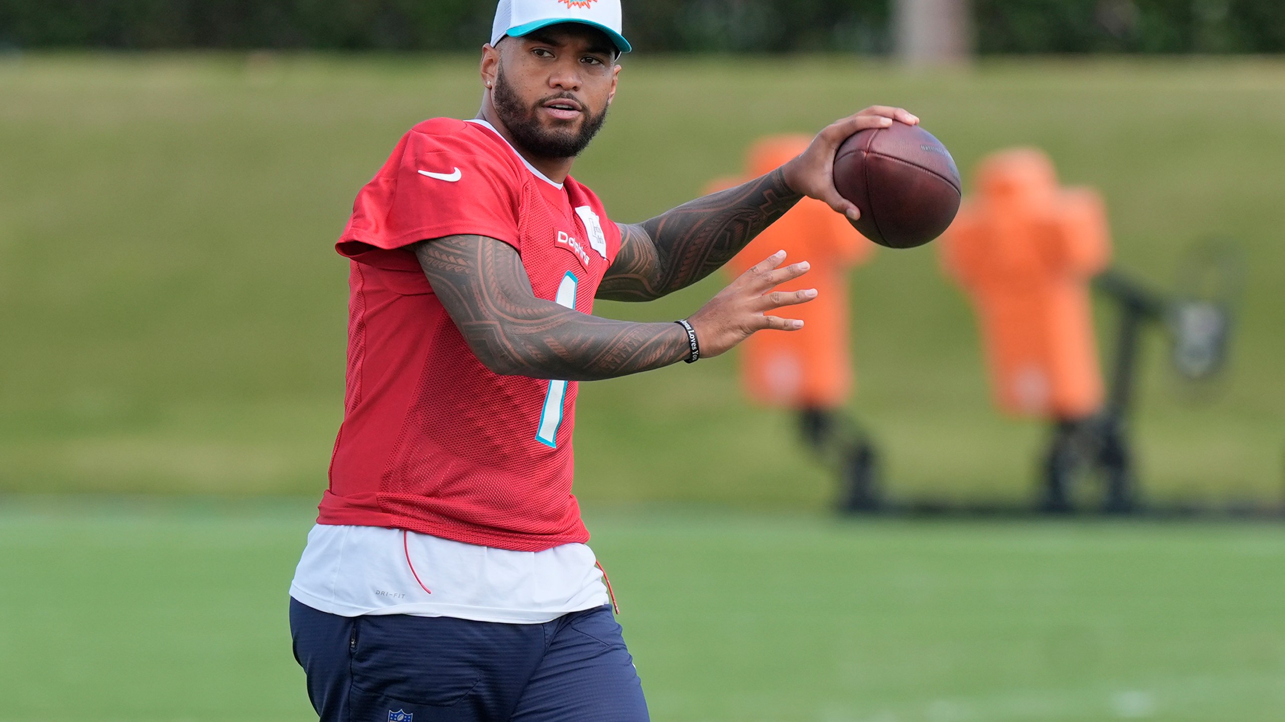 Miami Dolphins quarterback Tua Tagovailoa (1) aims the ball during a practice session at the team's training facility, Wednesday, Oct. 23, 2024, in Miami Gardens, Fla. (AP Photo/Marta Lavandier)