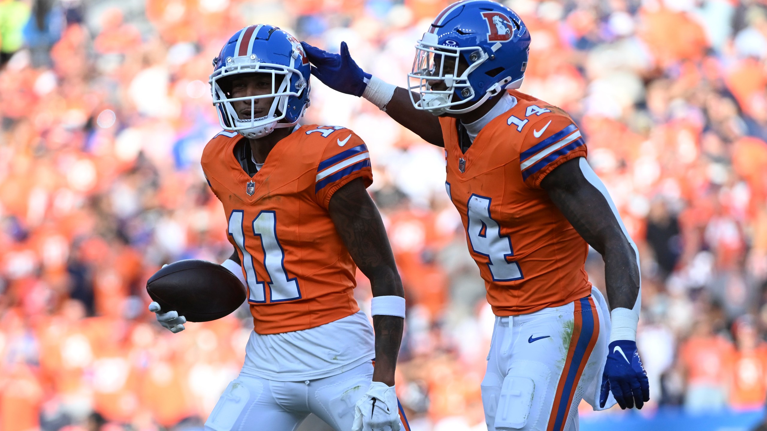 Denver Broncos wide receiver Josh Reynolds (11) celebrates his 9-yard reception for a touchdown with teammate wide receiver Courtland Sutton (14) during the second half of an NFL football game against the Las Vegas Raiders, Sunday, Oct. 6, 2024, in Denver. (AP Photo/Geneva Heffernan)