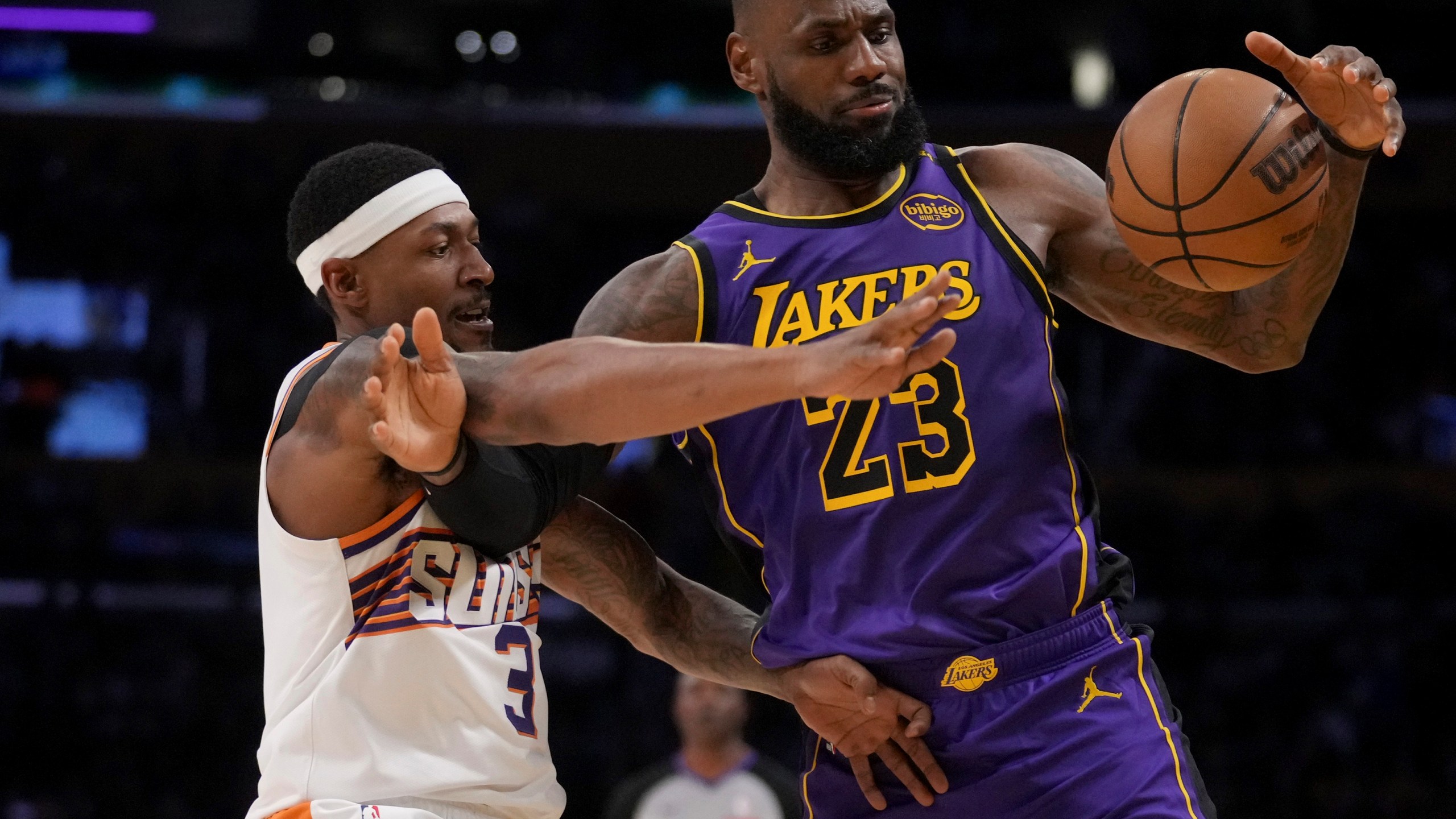 Los Angeles Lakers forward LeBron James (23) and Phoenix Suns guard Bradley Beal (3) fight for a loose ball during the second half of an NBA basketball game in Los Angeles, Friday, Oct. 25, 2024. (AP Photo/Eric Thayer)