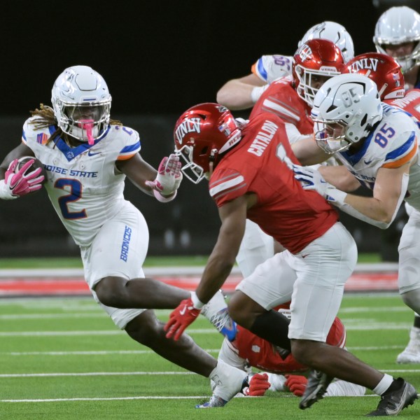 Boise State running back Ashton Jeanty (2) keeps UNLV defensive back Jalen Catalon (1) away during the first half of an NCAA college football game Friday, Oct. 25, 2024, in Las Vegas. (AP Photo/Sam Morris)