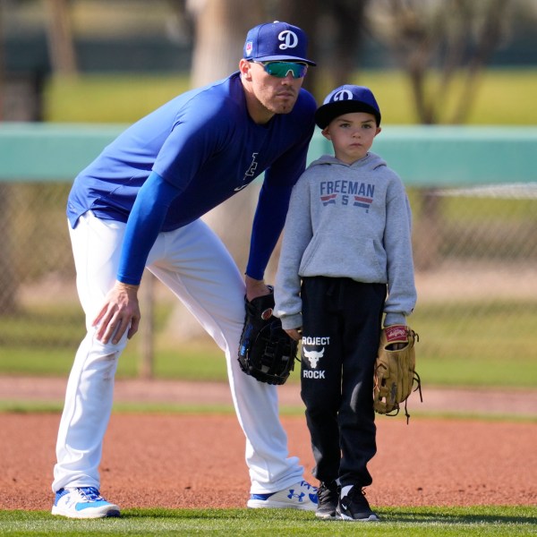 FILE - Los Angeles Dodgers first baseman Freddie Freeman, left, and his son Charlie, right, participate in spring training baseball workouts at Camelback Ranch in Phoenix, Feb. 18, 2024. (AP Photo/Ashley Landis, File)