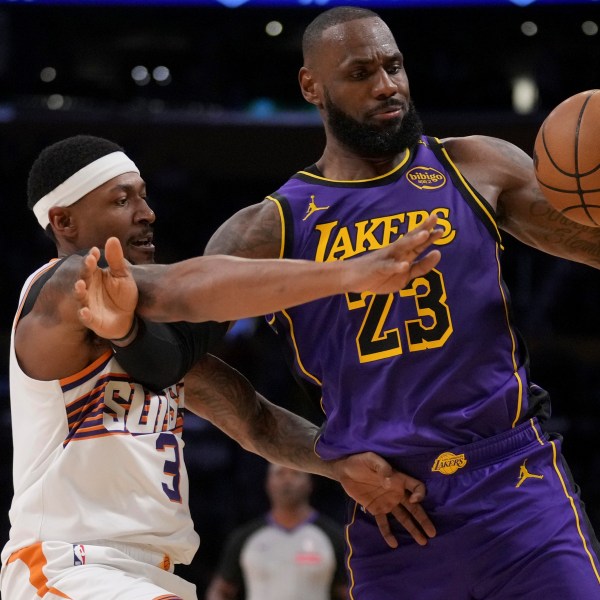 Los Angeles Lakers forward LeBron James (23) and Phoenix Suns guard Bradley Beal (3) fight for a loose ball during the second half of an NBA basketball game in Los Angeles, Friday, Oct. 25, 2024. (AP Photo/Eric Thayer)