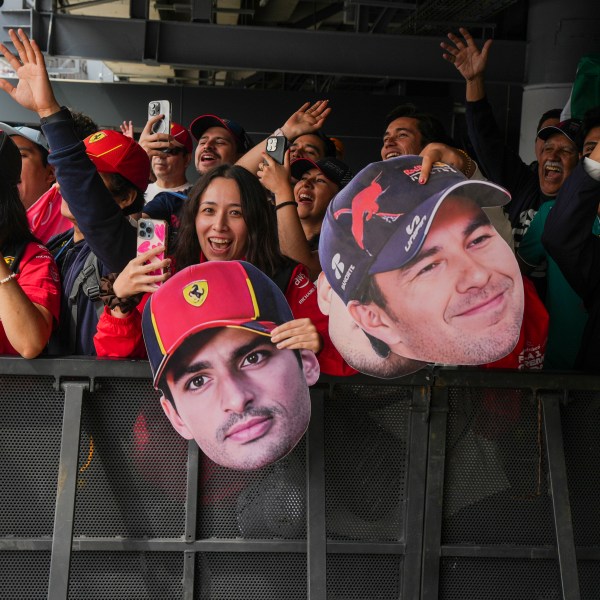 Fans hold cutouts of Ferrari driver Carlos Sainz, center, of Spain, and Red Bull driver Sergio Perez, of Mexico, during the third free practice one day ahead of the Formula One Mexico Grand Prix auto race at the Hermanos Rodriguez racetrack in Mexico City, Saturday, Oct. 26, 2024. (AP Photo/Fernando Llano)