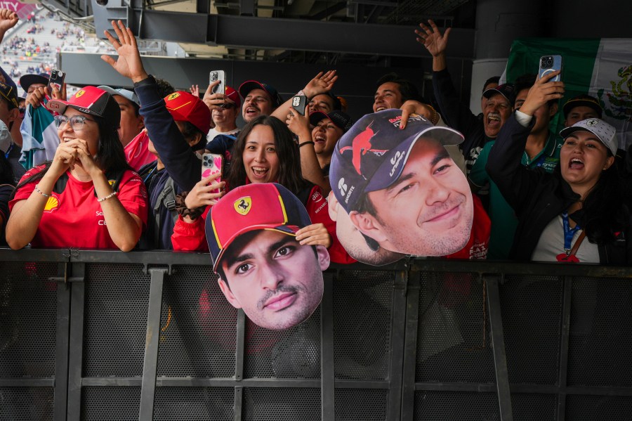 Fans hold cutouts of Ferrari driver Carlos Sainz, center, of Spain, and Red Bull driver Sergio Perez, of Mexico, during the third free practice one day ahead of the Formula One Mexico Grand Prix auto race at the Hermanos Rodriguez racetrack in Mexico City, Saturday, Oct. 26, 2024. (AP Photo/Fernando Llano)