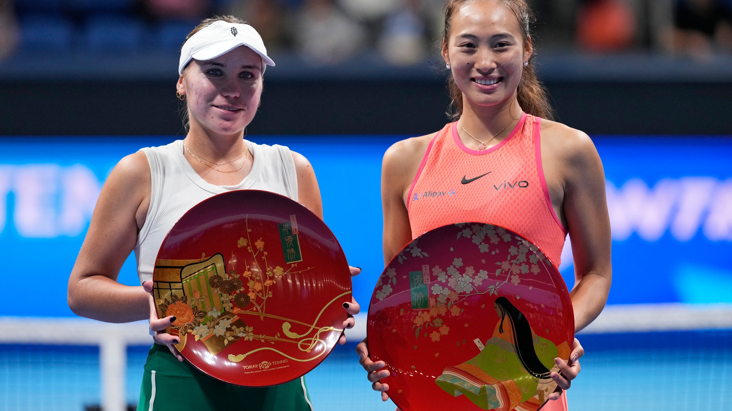 China's Zheng Qinwen, right, and Sofia Kenin of the United States pose with their trophies after winning the first and second place respectively in the Pan Pacific Open women's tennis tournament at Ariake Coliseum, in Tokyo, Sunday, Oct. 27, 2024. (AP Photo/Eugene Hoshiko)