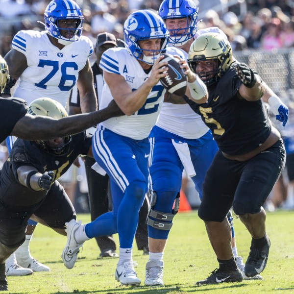 BYU quarterback Jake Retzlaff, Center, is sacked by Central Florida's defense during the first half of an NCAA college football game, Saturday, Oct. 26, 2024, in Orlando, Fla. (AP Photo/Kevin Kolczynski)