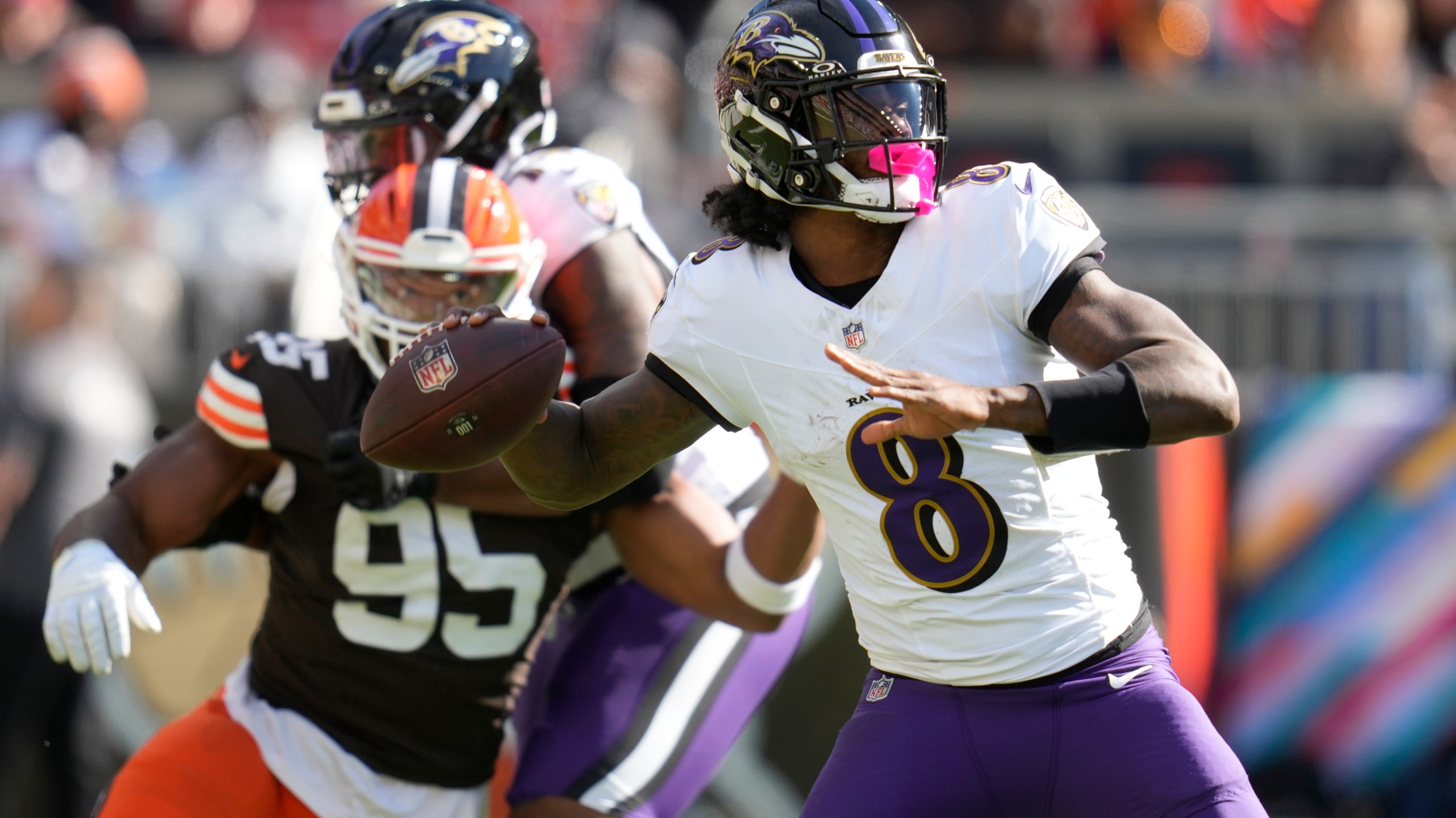 Baltimore Ravens quarterback Lamar Jackson (8) throws in from top Cleveland Browns defensive end Myles Garrett (95) during the first half of an NFL football game in Cleveland, Sunday, Oct. 27, 2024. (AP Photo/Sue Ogrocki)