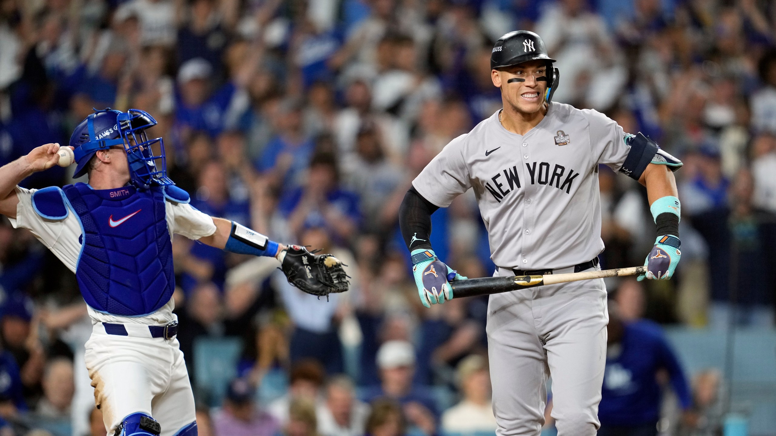 New York Yankees' Aaron Judge, right, reacts after striking out as Los Angeles Dodgers catcher Will Smith throws the ball around the infield during the sixth inning in Game 2 of the baseball World Series, Saturday, Oct. 26, 2024, in Los Angeles. (AP Photo/Godofredo A. Vásquez)