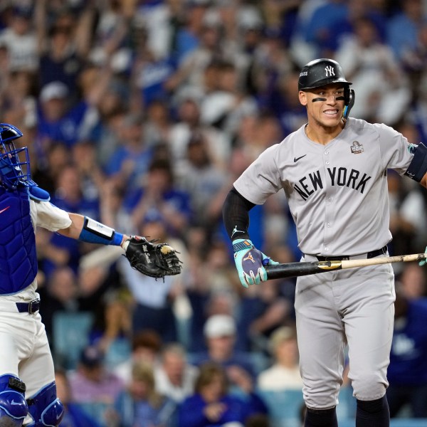 New York Yankees' Aaron Judge, right, reacts after striking out as Los Angeles Dodgers catcher Will Smith throws the ball around the infield during the sixth inning in Game 2 of the baseball World Series, Saturday, Oct. 26, 2024, in Los Angeles. (AP Photo/Godofredo A. Vásquez)