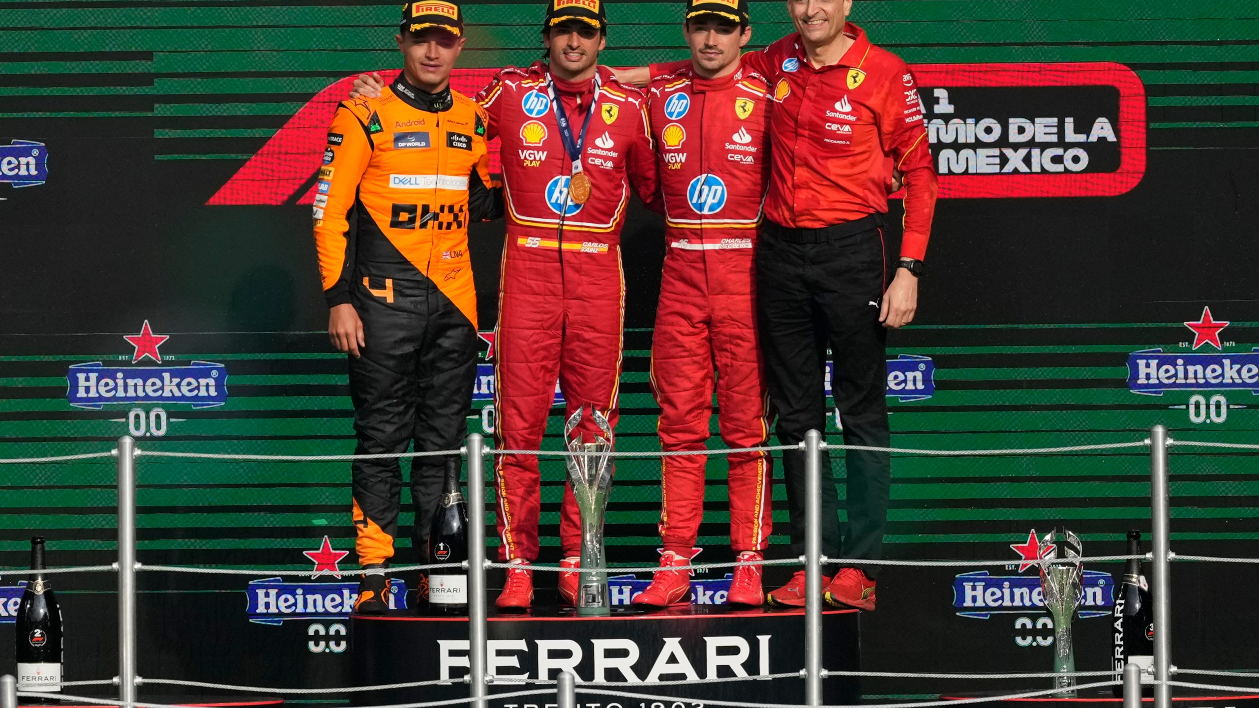 From left, McLaren driver Lando Norris of Britain, second place, Ferrari driver Carlos Sainz of Spain, first place, Ferrari driver Charles Leclerc of Monaco, third place, and Riccardo Adami of Ferrari pose on the podium for the Formula One Mexico Grand Prix auto race at the Hermanos Rodriguez racetrack in Mexico City, Sunday, Oct. 27, 2024. (AP Photo/Eduardo Verdugo)