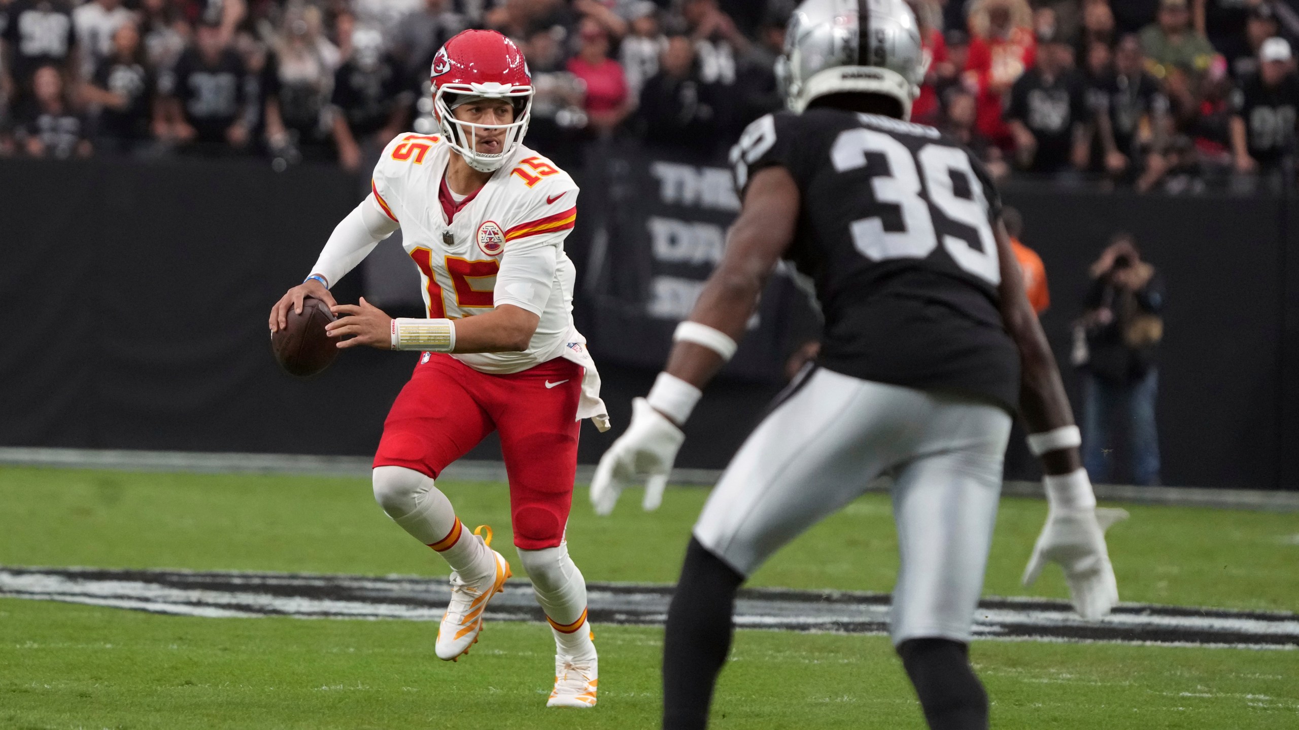 Kansas City Chiefs quarterback Patrick Mahomes (15) scrambles as Las Vegas Raiders cornerback Nate Hobbs (39) defends during the first half of an NFL football game Sunday, Oct. 27, 2024, in Las Vegas. (AP Photo/Rick Scuteri)