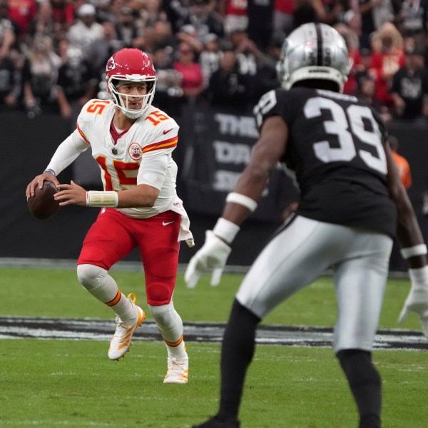 Kansas City Chiefs quarterback Patrick Mahomes (15) scrambles as Las Vegas Raiders cornerback Nate Hobbs (39) defends during the first half of an NFL football game Sunday, Oct. 27, 2024, in Las Vegas. (AP Photo/Rick Scuteri)