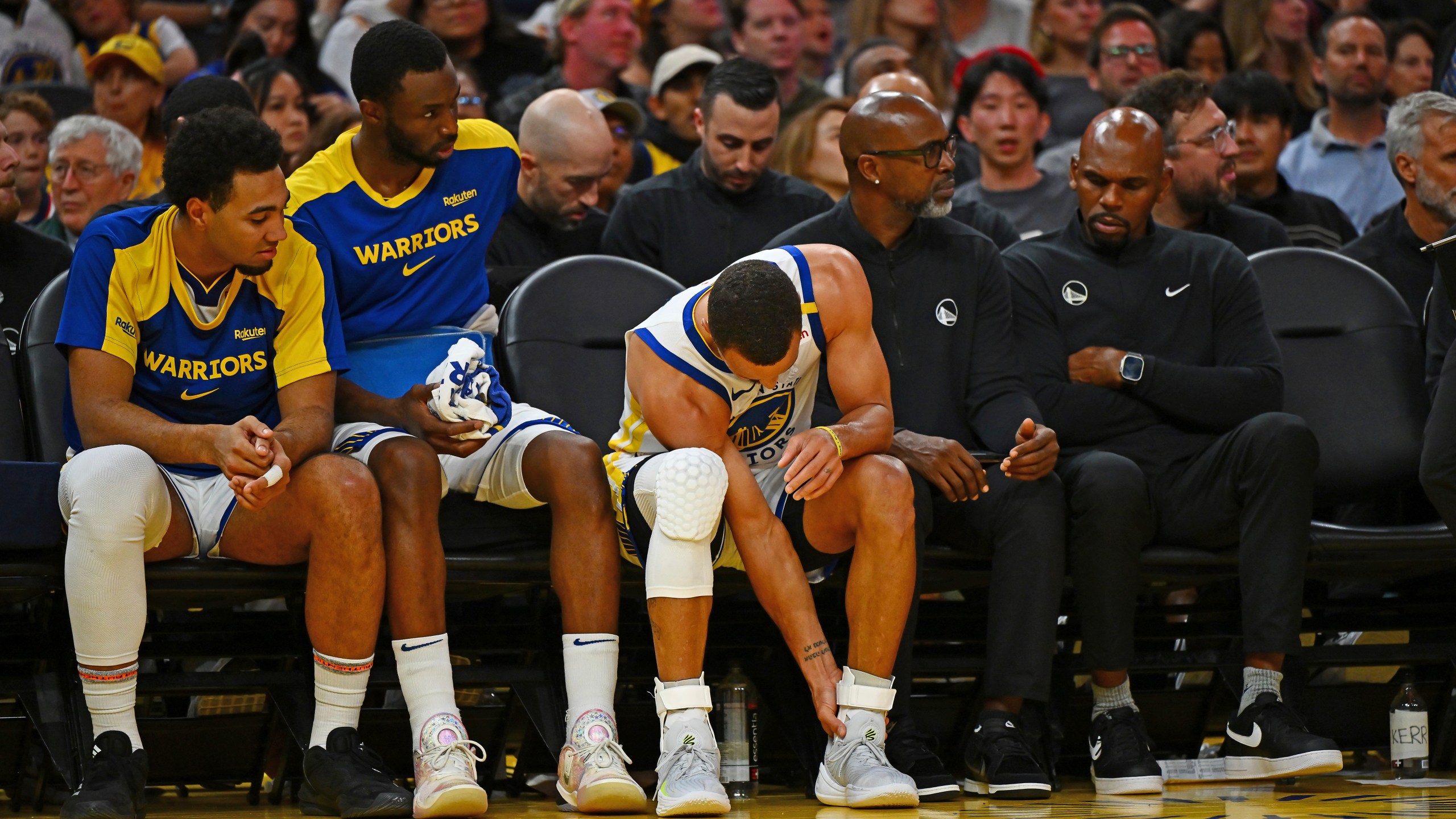 Golden State Warriors' Stephen Curry, center, holds his left ankle after sustaining an injury in the third quarter of an NBA basketball game against the Los Angeles Clippers in San Francisco, Sunday, Oct. 27, 2024. (Jose Carlos Fajardo/Bay Area News Group via AP)