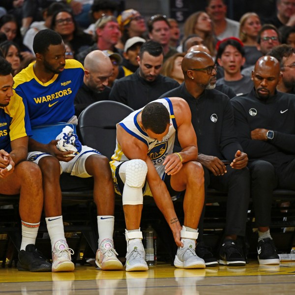 Golden State Warriors' Stephen Curry, center, holds his left ankle after sustaining an injury in the third quarter of an NBA basketball game against the Los Angeles Clippers in San Francisco, Sunday, Oct. 27, 2024. (Jose Carlos Fajardo/Bay Area News Group via AP)