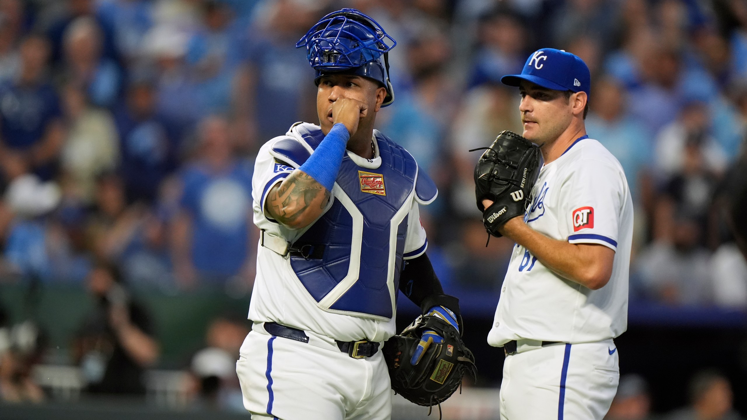 Kansas City Royals catcher Salvador Perez, left, and starting pitcher Seth Lugo pause as a play undergoes video review during the third inning in Game 3 of an American League Division baseball playoff series against the New York Yankees Wednesday, Oct. 9, 2024, in Kansas City, Mo. (AP Photo/Charlie Riedel)