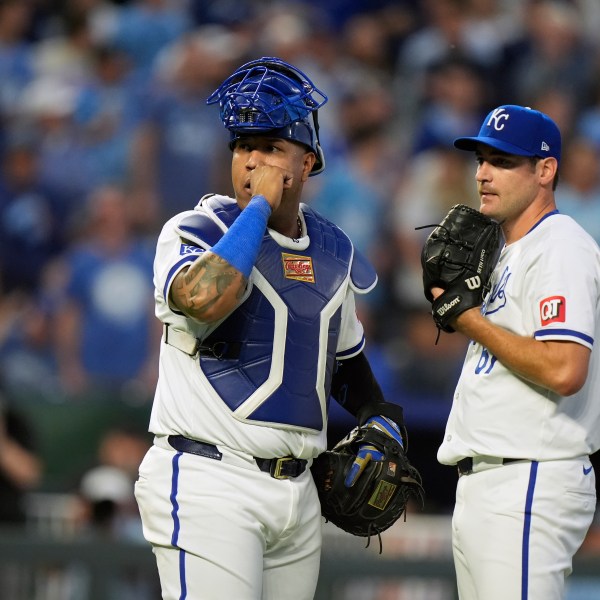 Kansas City Royals catcher Salvador Perez, left, and starting pitcher Seth Lugo pause as a play undergoes video review during the third inning in Game 3 of an American League Division baseball playoff series against the New York Yankees Wednesday, Oct. 9, 2024, in Kansas City, Mo. (AP Photo/Charlie Riedel)