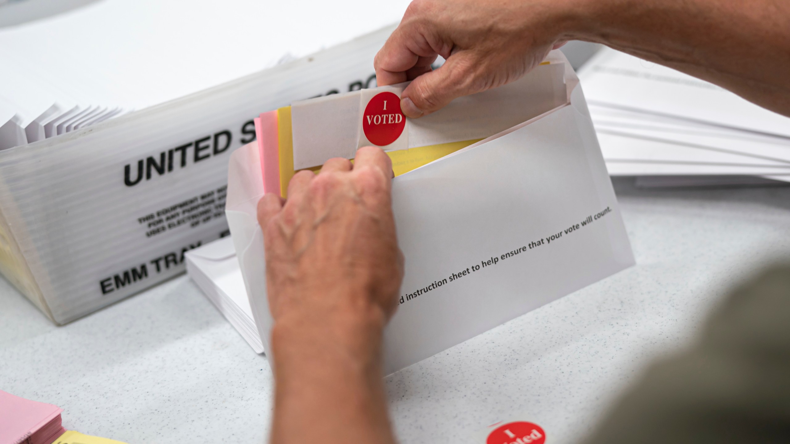 FILE - Mail in ballot envelopes including an I Voted sticker are prepared in Minneapolis, July 29, 2020. (Glen Stubbe/Star Tribune via AP, File)