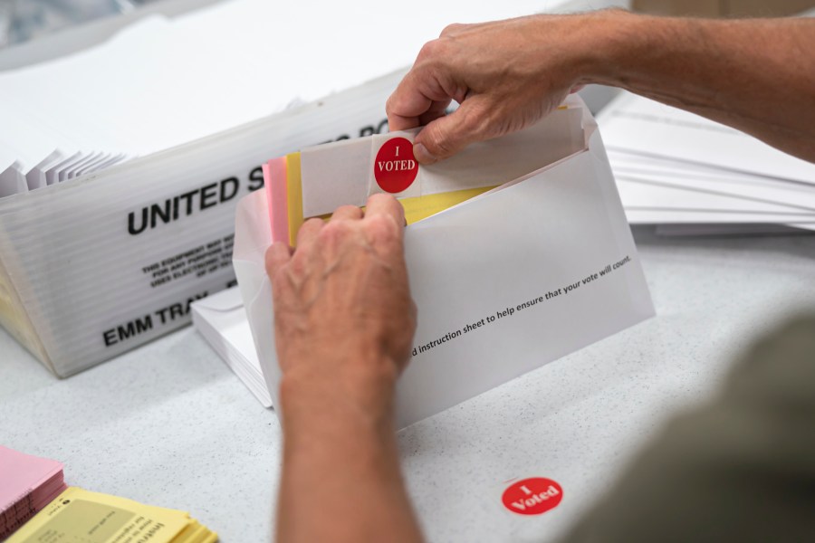 FILE - Mail in ballot envelopes including an I Voted sticker are prepared in Minneapolis, July 29, 2020. (Glen Stubbe/Star Tribune via AP, File)