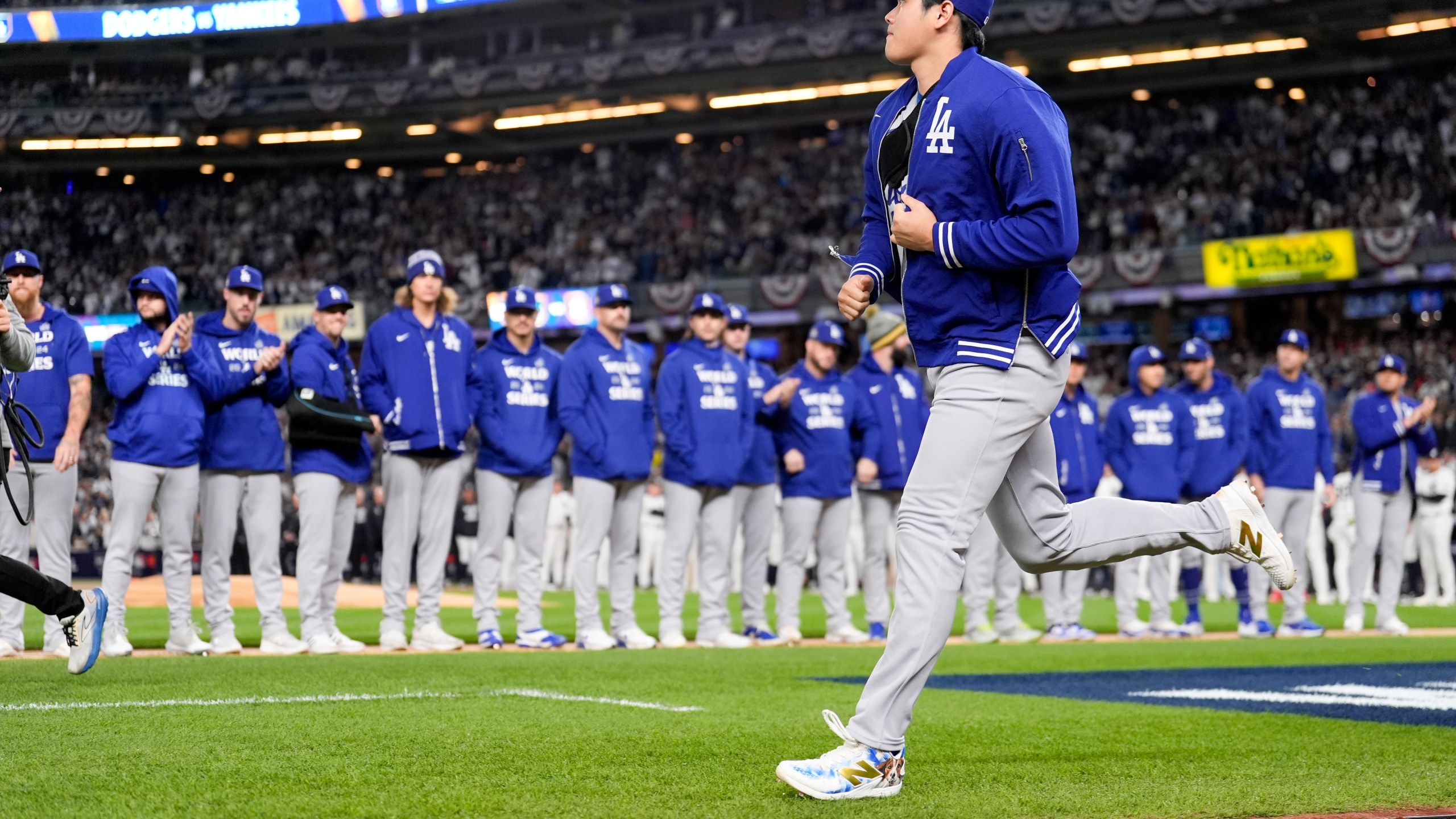 Los Angeles Dodgers' Shohei Ohtani run onto the field for introductions before Game 3 of the baseball World Series against the New York Yankees, Monday, Oct. 28, 2024, in New York. (AP Photo/Ashley Landis)