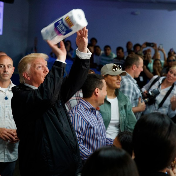 FILE - President Donald Trump tosses paper towels into a crowd at Calvary Chapel in Guaynabo, Puerto Rico, Oct. 3, 2017. (AP Photo/Evan Vucci, File)