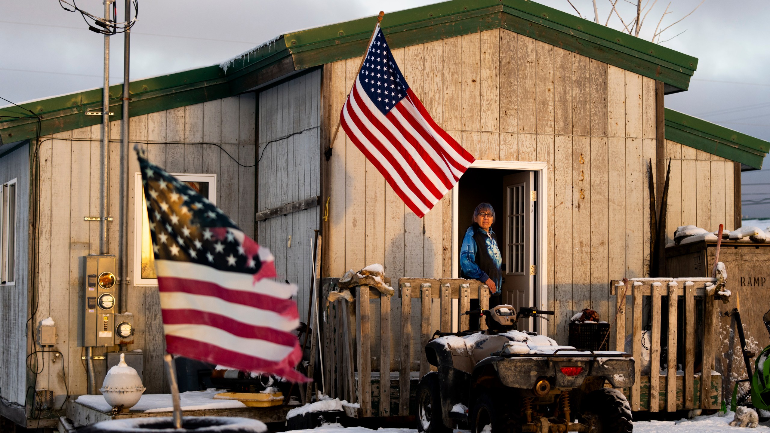 Alice Aishanna poses for a portrait outside her home displaying several American flags in Kaktovik, Alaska, Tuesday, Oct. 15, 2024. (AP Photo/Lindsey Wasson)