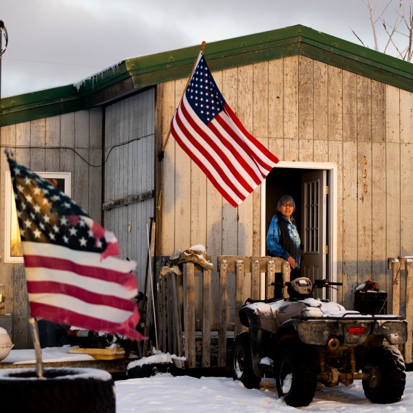 Alice Aishanna poses for a portrait outside her home displaying several American flags in Kaktovik, Alaska, Tuesday, Oct. 15, 2024. (AP Photo/Lindsey Wasson)