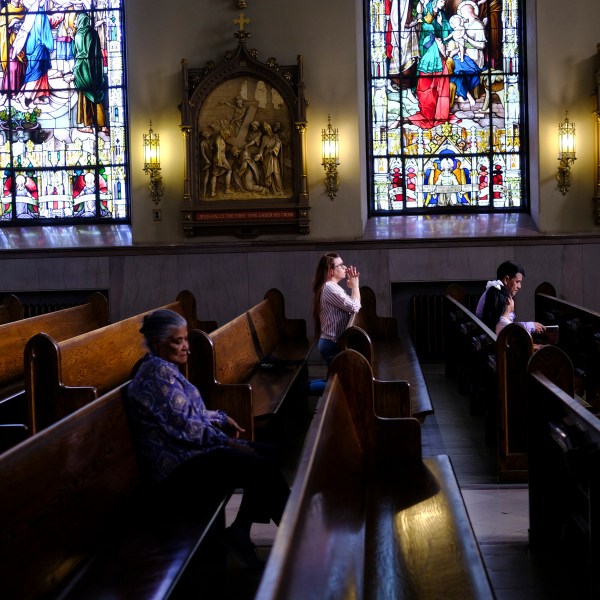 FILE - A parishioner prays at St. Peter the Apostle Catholic Church in Reading, Pa., on June 16, 2024. (AP Photo/Luis Andres Henao)