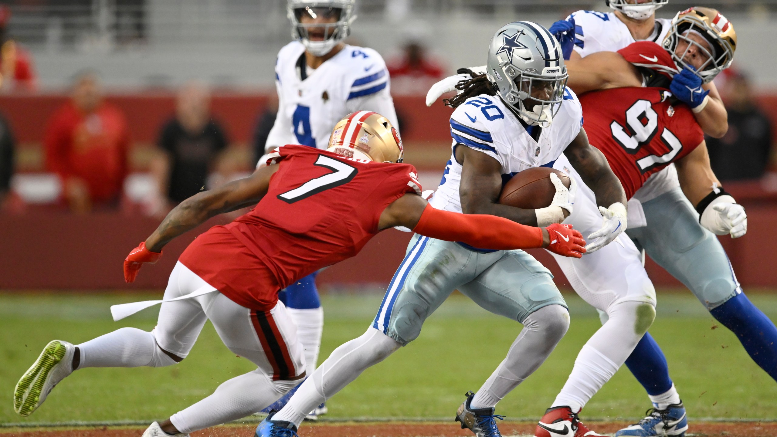 Dallas Cowboys running back Dalvin Cook (20) runs between San Francisco 49ers cornerback Charvarius Ward (7) and defensive end Nick Bosa (97) during the first half of an NFL football game in Santa Clara, Calif., Sunday, Oct. 27, 2024. (AP Photo/Eakin Howard)