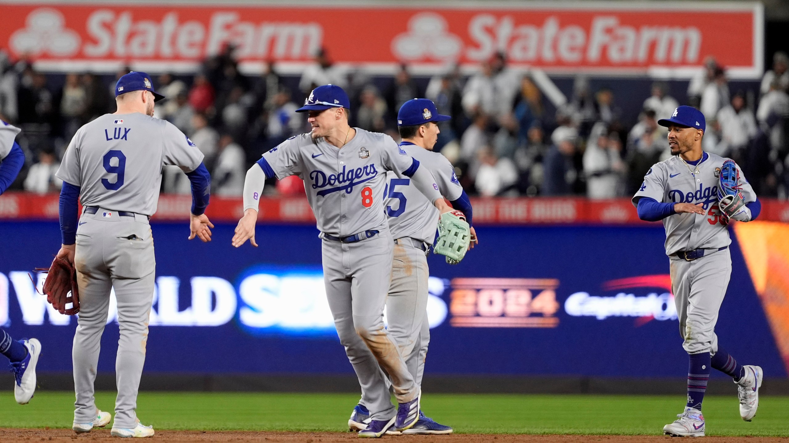 Los Angeles Dodgers' Gavin Lux (9), Kiké Hernández (8), Tommy Edman (25) and Mookie Betts (50) celebrate after Game 3 of the baseball World Series against the New York Yankees, Monday, Oct. 28, 2024, in New York. The Dodgers won 4-2. (AP Photo/Godofredo A. Vásquez)