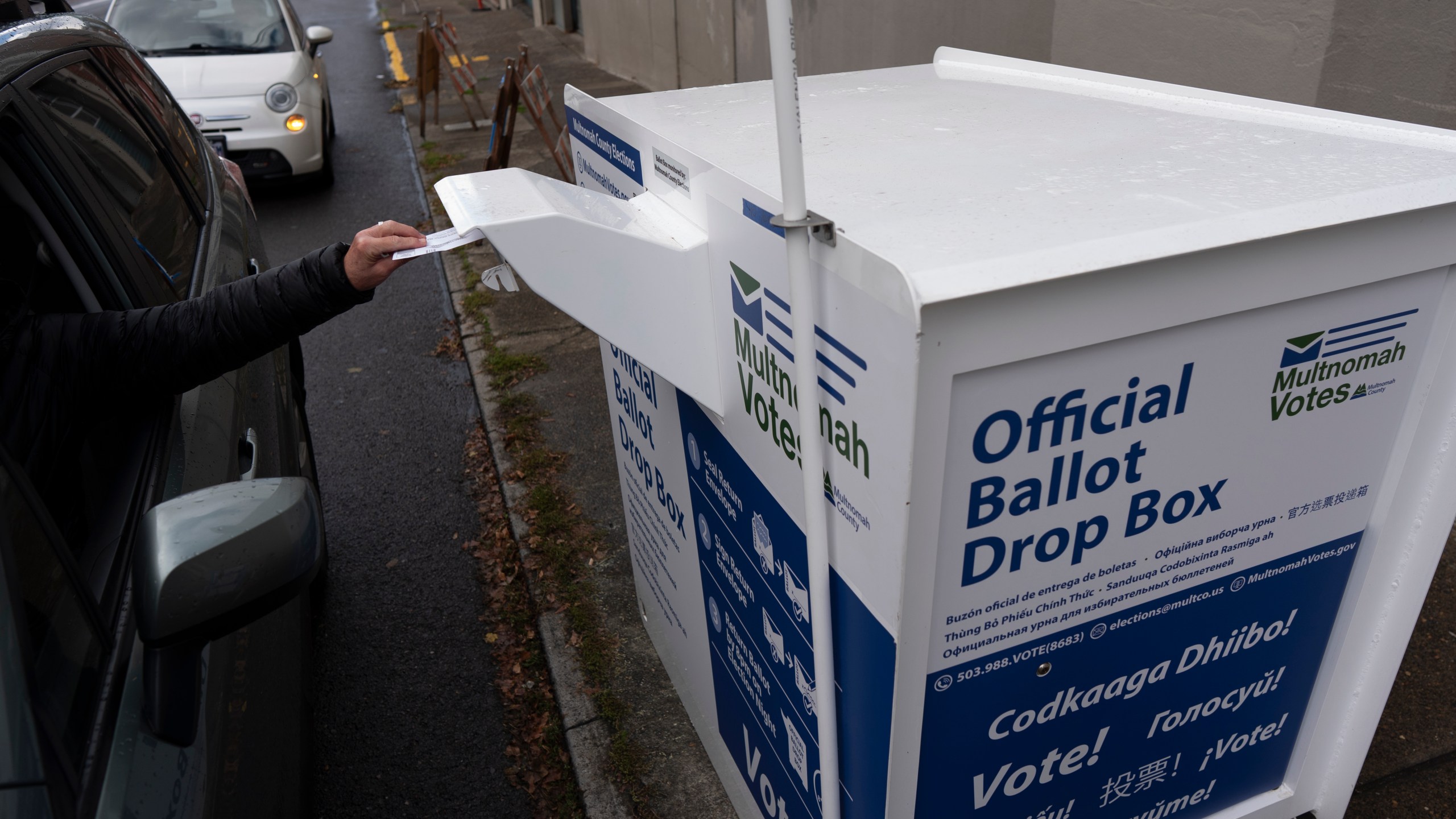 A person drops off their 2024 election ballot at a newly installed drop box outside the Multnomah County Elections Division office on Monday, Oct. 28, 2024, in Portland, Ore. (AP Photo/Jenny Kane)