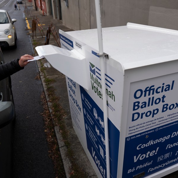 A person drops off their 2024 election ballot at a newly installed drop box outside the Multnomah County Elections Division office on Monday, Oct. 28, 2024, in Portland, Ore. (AP Photo/Jenny Kane)